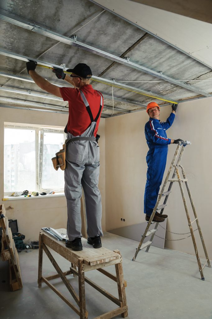 workers measure metal frame